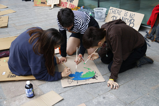 Fridays for Future climate activists in Girona painting a sign (by Aleix Freixas)